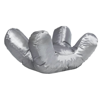 The Anti-Wrinkle Face Pillow from Gina’s Store is a shiny silver, ergonomic pillow shaped like an open hand with three raised fingers and a thumb, resembling a stylized glove, displayed on a white background.